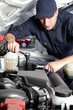 Car mechanic working in auto repair service.