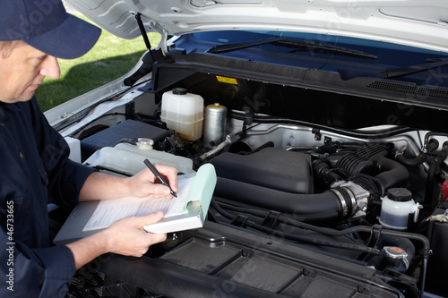 Photo: Car mechanic working in auto repair service. Car mechanic working in auto repair service.