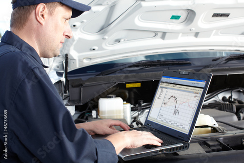 Photo: Car mechanic working in auto repair service. Car mechanic working in auto repair service.