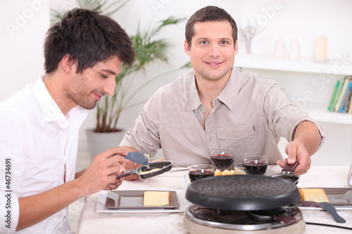 Photo: Two men enjoying a Raclette Two men enjoying a Raclette