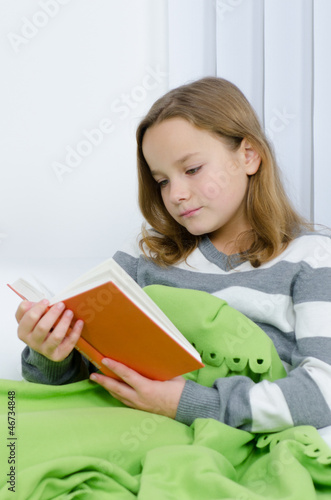 Photo: Mädchen liest interessiert ein Buch Mädchen liest interessiert ein Buch
