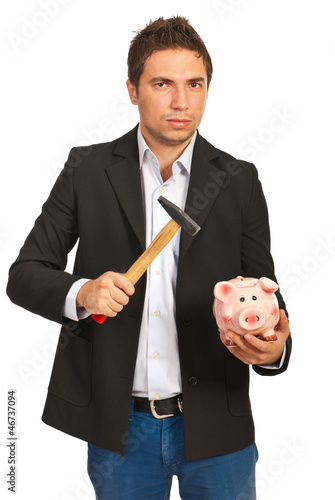 Photo: Nervous man holding hammer and piggybank Nervous man holding hammer and piggybank