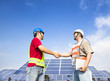 two engineers handshaking  before large solar power station