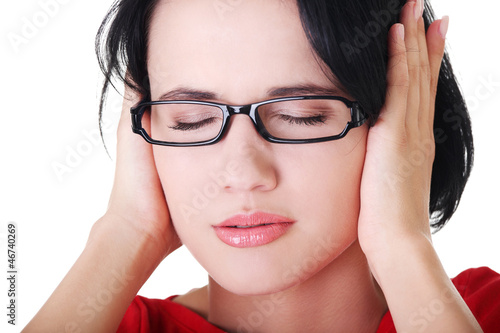 Photo: Frustrated young woman holding her ears Frustrated young woman holding her ears