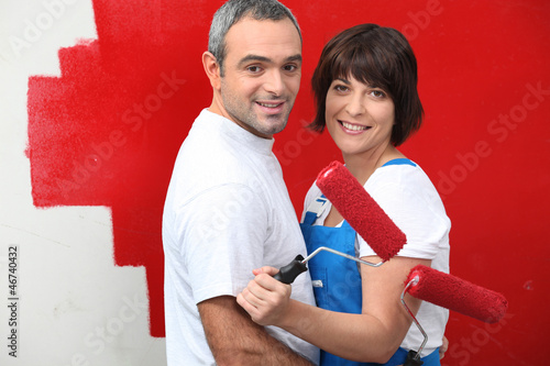 Photo: Couple painting a wall red Couple painting a wall red