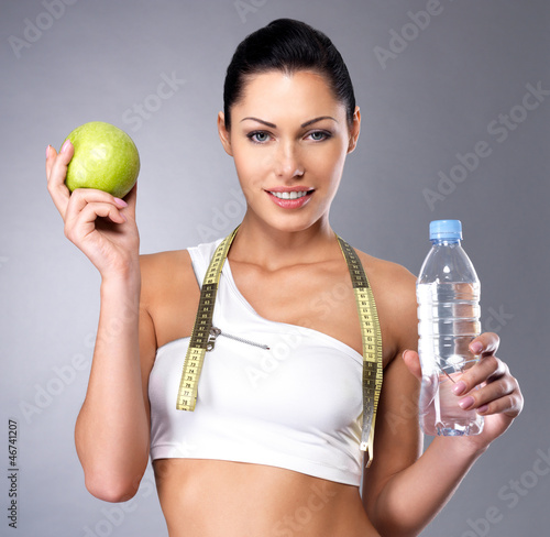 Photo: Healthy woman with apple and bottle of water Healthy woman with apple and bottle of water