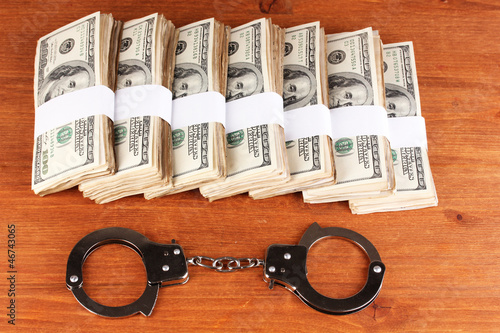 Photo: idea of punishment for financial fraud, on wooden background idea of punishment for financial fraud, on wooden background