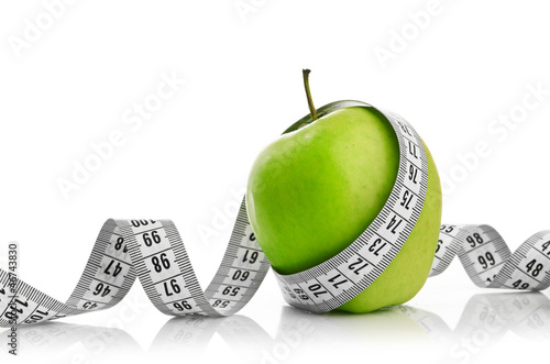 Photo: Measuring tape wrapped around a green apple Measuring tape wrapped around a green apple