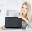 blonde frau zeigt etwas am laptop