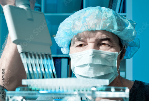 Photo: Senior scientist loads samples for DNA analysis Senior scientist loads samples for DNA analysis