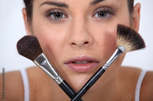 Photo: Closeup of a woman with makeup brushes Closeup of a woman with makeup brushes
