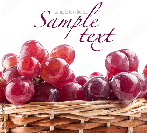 Photo: Red grape in a wicker basket, on a white background Red grape in a wicker basket, on a white background