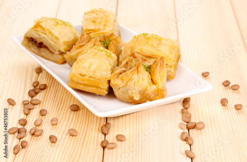 Photo: Sweet baklava on plate on wooden background Sweet baklava on plate on wooden background