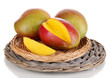 Ripe appetizing mango on wicker cradle isolated on white