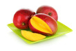 Ripe appetizing mango on green plate isolated on white