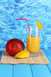Ripe appetizing mango on woven napkin on water background
