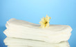 Panty liners and yellow flower on blue background close-up