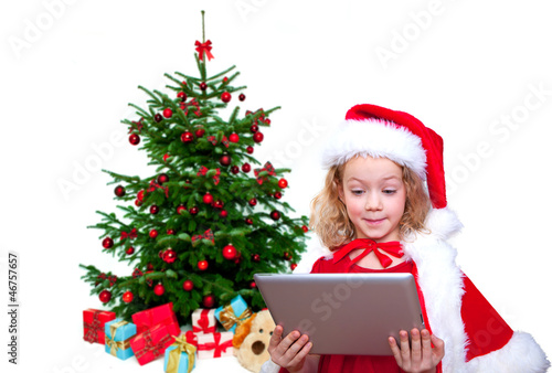 Photo: kind mit tablet vorm weihnachtsbaum kind mit tablet vorm weihnachtsbaum