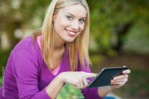 Photo: Woman using digital tablet outdoors Woman using digital tablet outdoors