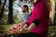Couple doing yoga meditation in a forest