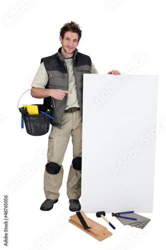 Photo: Tiler pointing at blank advertising panel Tiler pointing at blank advertising panel
