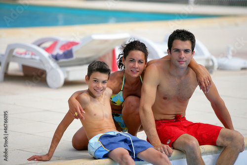 Photo: Family sitting by a pool Family sitting by a pool