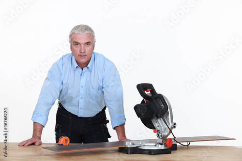 Photo: Grey-haired man with circular saw Grey-haired man with circular saw
