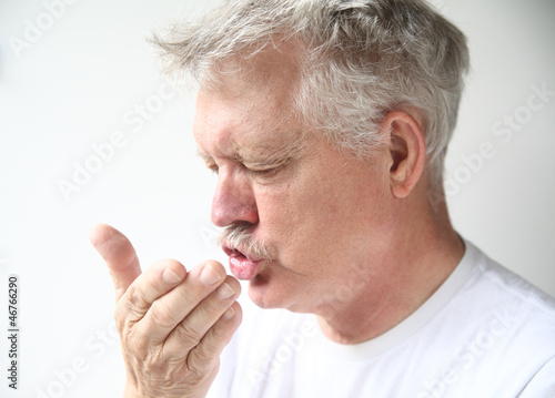 Photo: senior man sneezing into his hand senior man sneezing into his hand