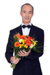 senior man in a suit holding flowers