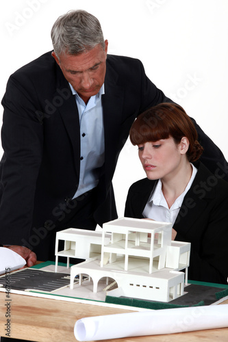 Photo: Architect and assistant looking at model house Architect and assistant looking at model house