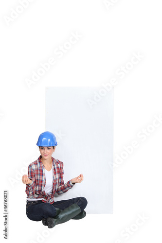 Photo: A female construction worker in the lotus position. A female construction worker in the lotus position.