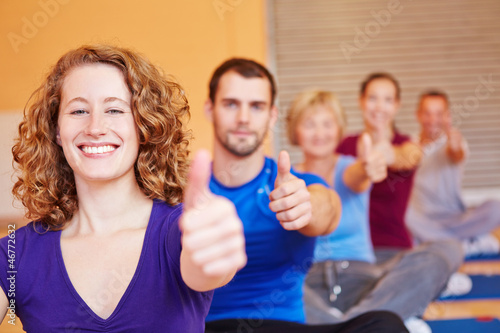 Photo: Frau im Fitnesskurs hält Daumen hoch Frau im Fitnesskurs hält Daumen hoch