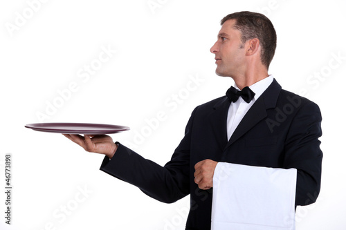 Photo: A waiter holding an empty tray A waiter holding an empty tray