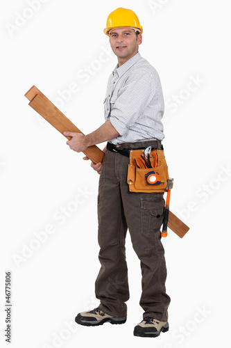 Photo: A carpenter carrying planks. A carpenter carrying planks.