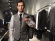 Businessman in classic vest against row of suits in shop