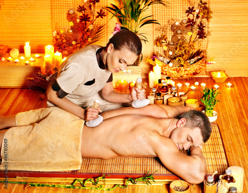 Photo: Man getting herbal ball massage treatments . Man getting herbal ball massage treatments .