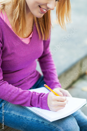 Photo: Female student writing Female student writing