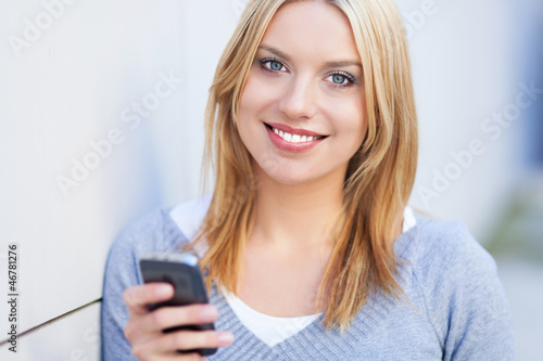 Photo: Young woman holding mobile phone Young woman holding mobile phone