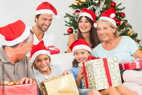 Photo: Happy family at christmas swapping gifts Happy family at christmas swapping gifts