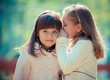 Happy little girlfriends in park