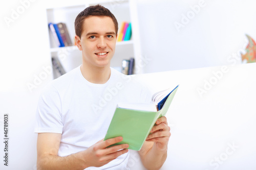 Photo: Young man at home with a book Young man at home with a book