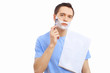Young man at home shaving himself