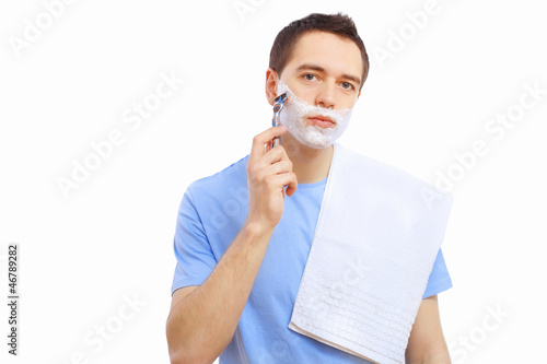 Photo: Young man at home shaving himself Young man at home shaving himself