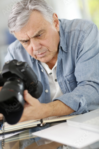 Photo: Photographer in office looking at camera screen Photographer in office looking at camera screen