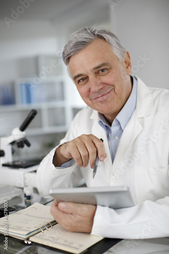 Photo: Portrait of scientist in lab using digital tablet Portrait of scientist in lab using digital tablet