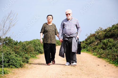 Photo: lovely senior couple walking on a path lovely senior couple walking on a path