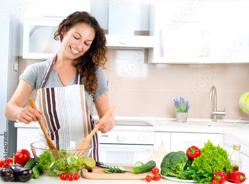 Photo: Young Woman Cooking. Healthy Food - Vegetable Salad Young Woman Cooking. Healthy Food - Vegetable Salad