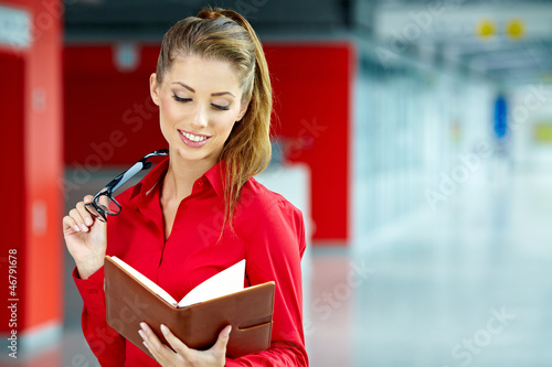 Photo: Portrait of a cute young business woman smiling, in an office en Portrait of a cute young business woman smiling, in an office en