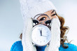 Photo: Beautiful young girl in winter clothes with alarm clock Beautiful young girl in winter clothes with alarm clock