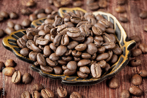 Photo: Coffee beans on old wooden board Coffee beans on old wooden board
